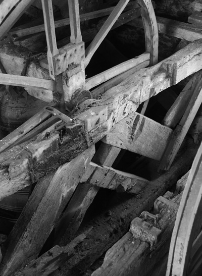The Whitechapel bell is visible in the background with the bell pit for one of the stolen bells in the foreground showing the rotated timbers and multiple bearing mounts.